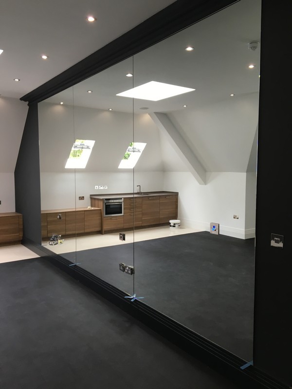 Frameless glass partition in loft conversion by Didcot glaziers